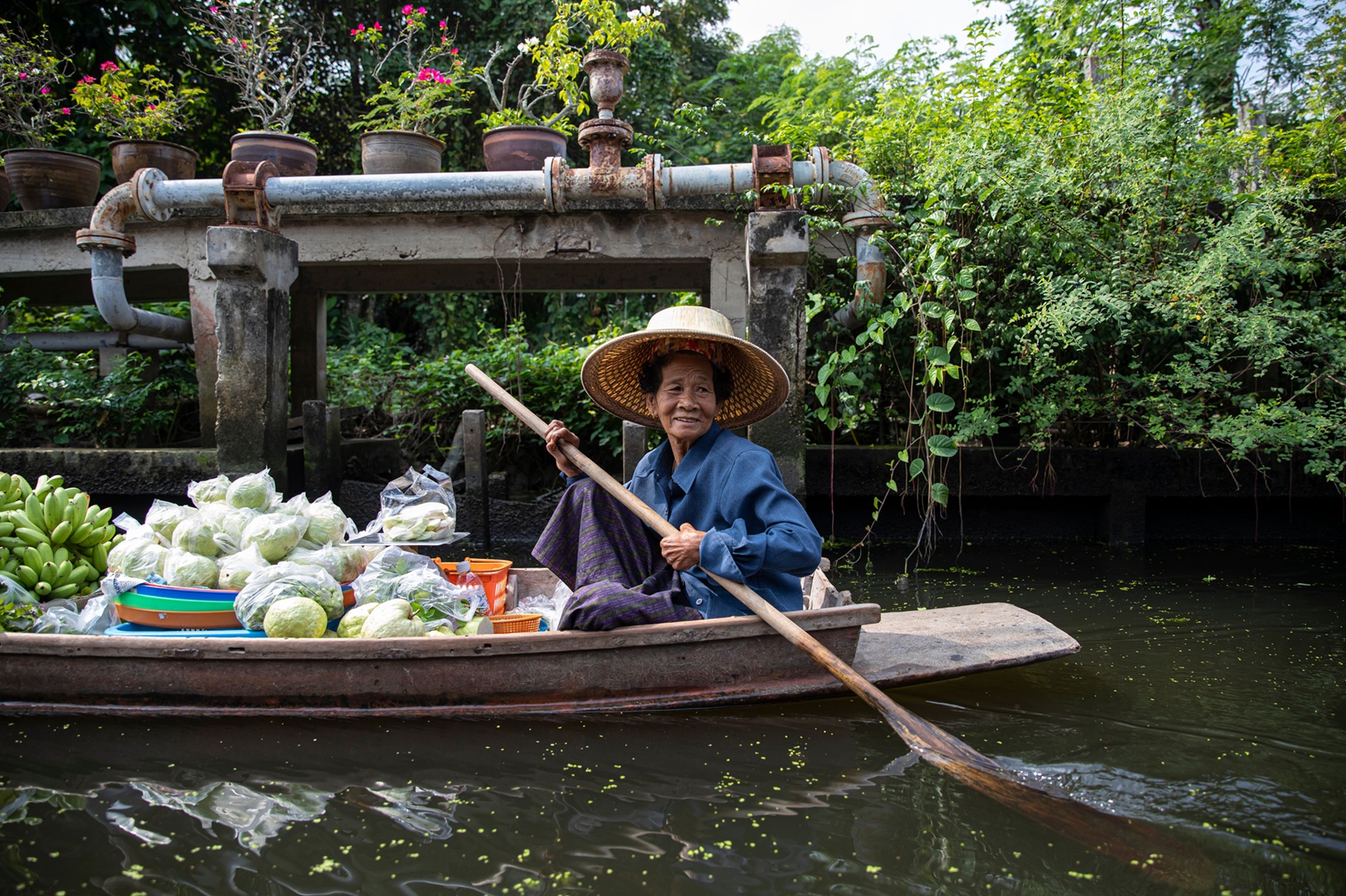 Una mujer local vende productos frescos desde su barco en un río